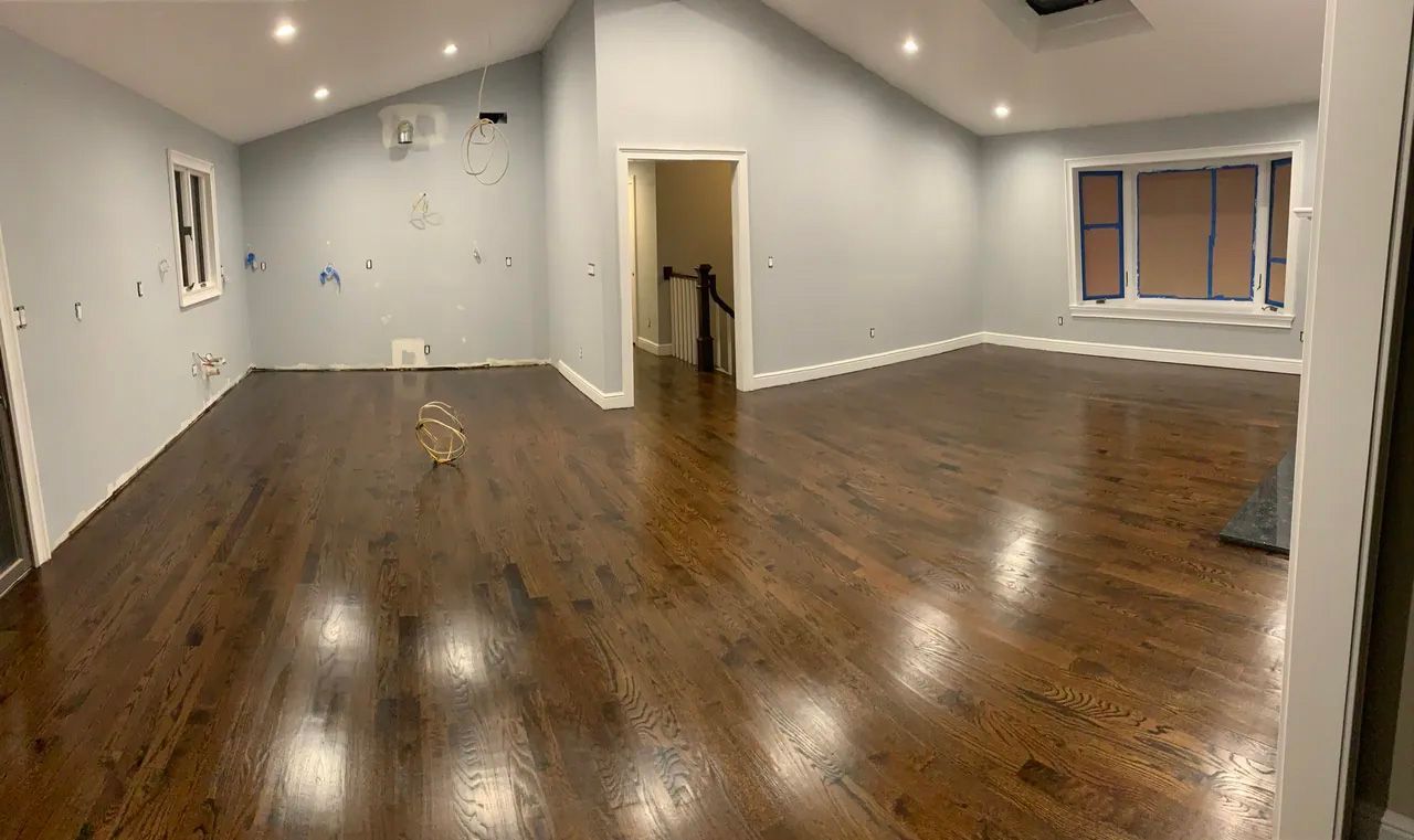 A large empty room with hardwood floors and a vaulted ceiling.