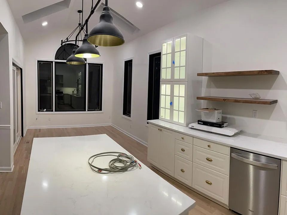 A kitchen with white cabinets and a stainless steel dishwasher.