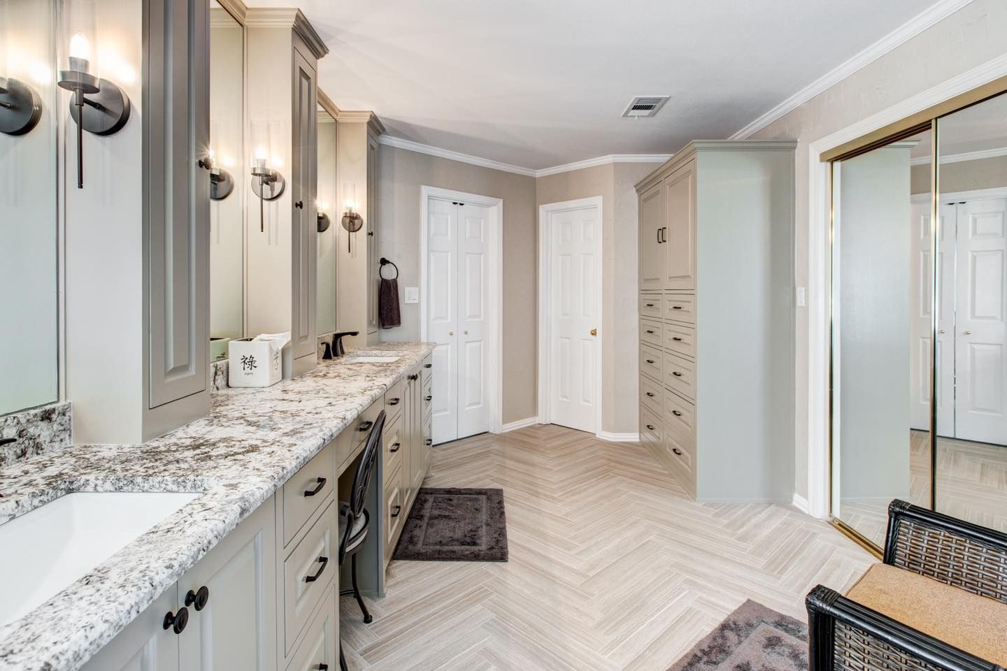 Bathroom with light gray cabinets, granite countertops, and herringbone tile floor.