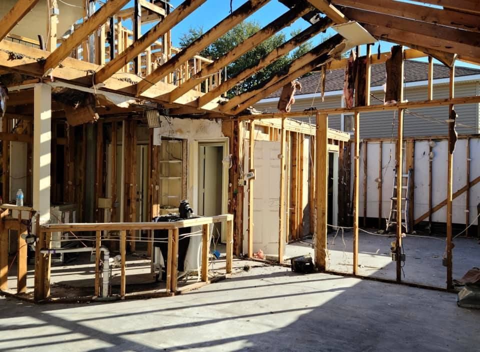 Exterior of a building undergoing demolition. Wooden beams and frames exposed. Damaged structure.