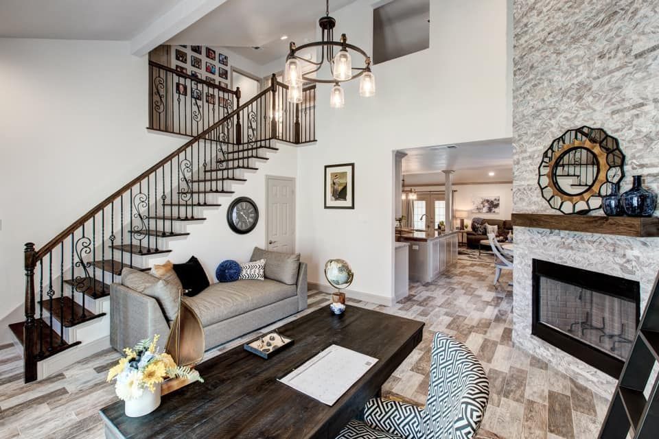 Interior with staircase, fireplace, seating area, and desk. Bright and airy space with neutral colors.
