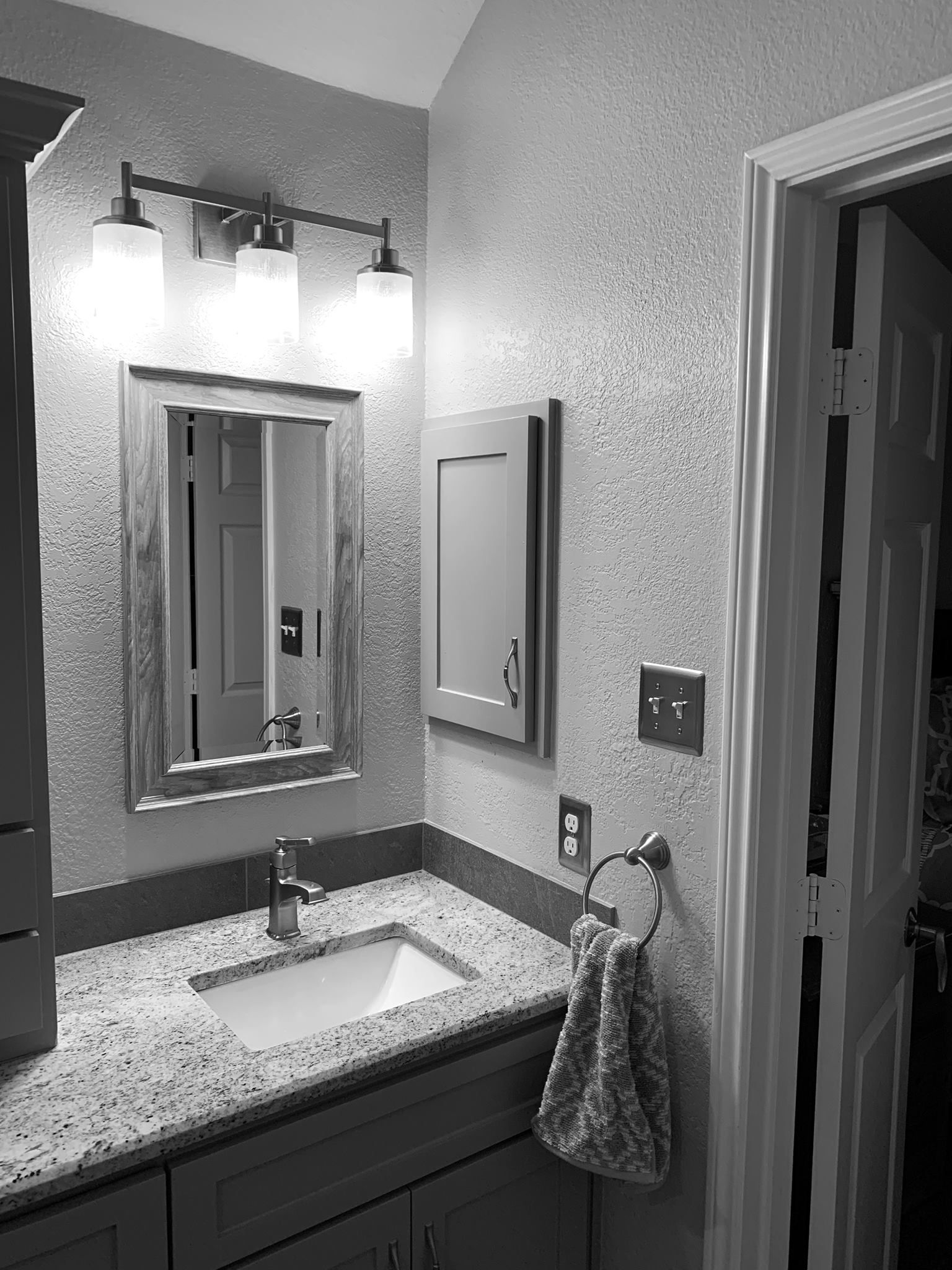 Bathroom with mirror, sink, medicine cabinet, and towel ring. Granite countertop. Neutral walls and trim.