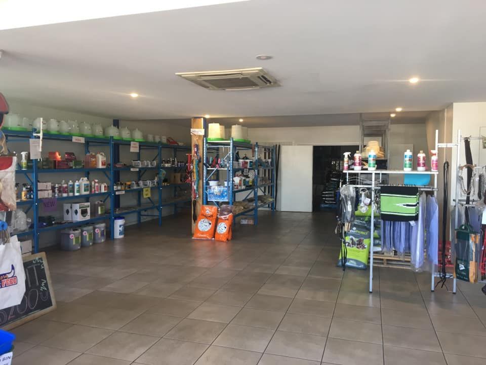 A Stack of Bags of Cool Grass is Sitting on Top of a Blue Pallet — Territory Stock Feed & Saddlery in Alice Springs, NT