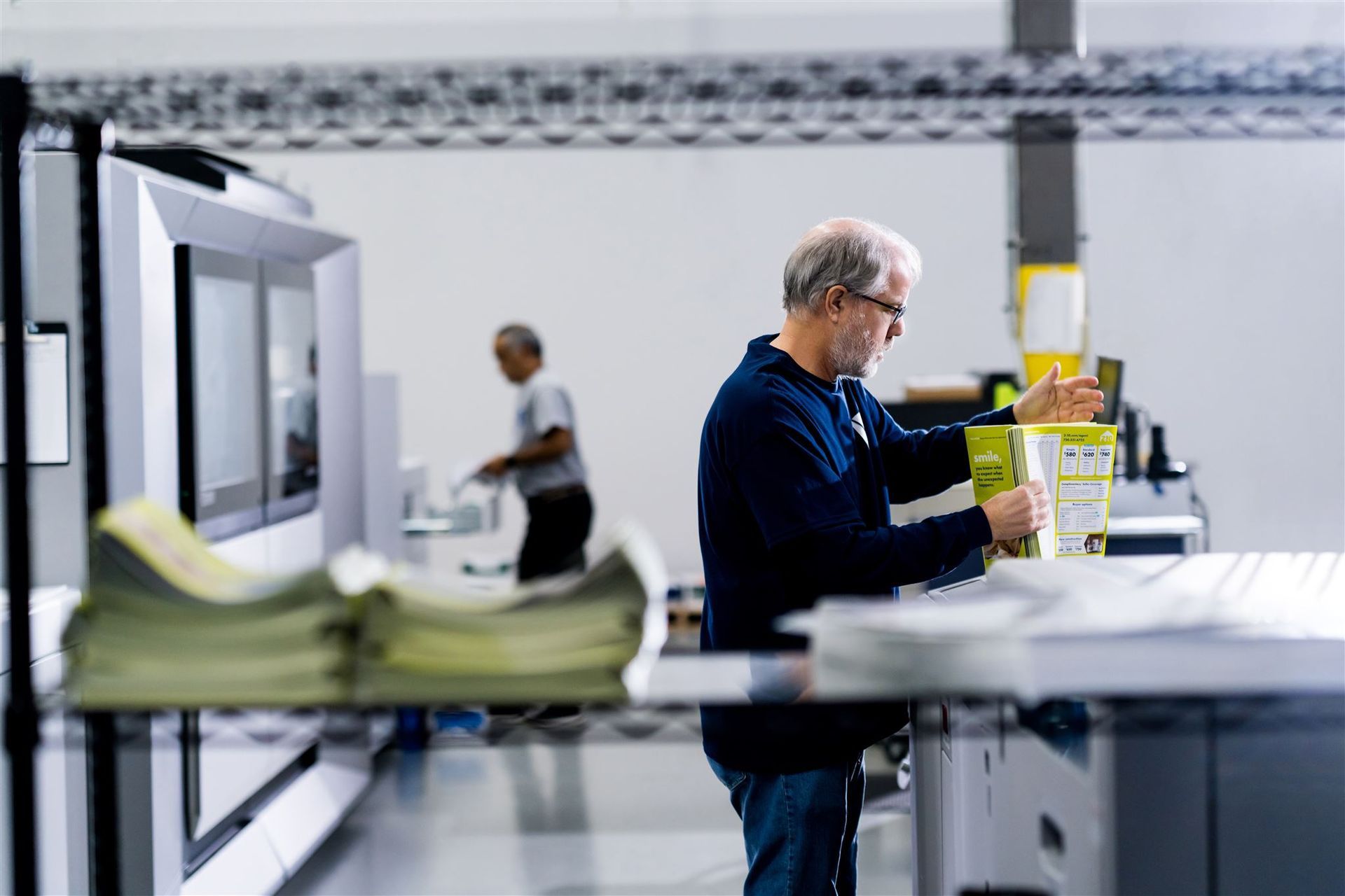 Person working at a lab bench with equipment and papers in a bright industrial workspace