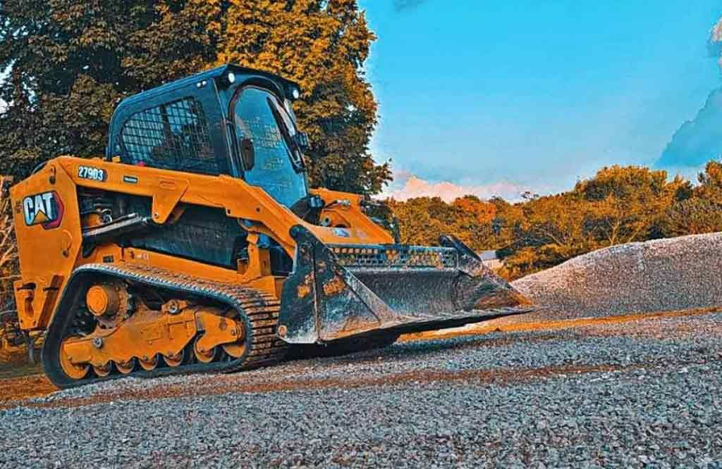 A bulldozer is driving down a gravel road.