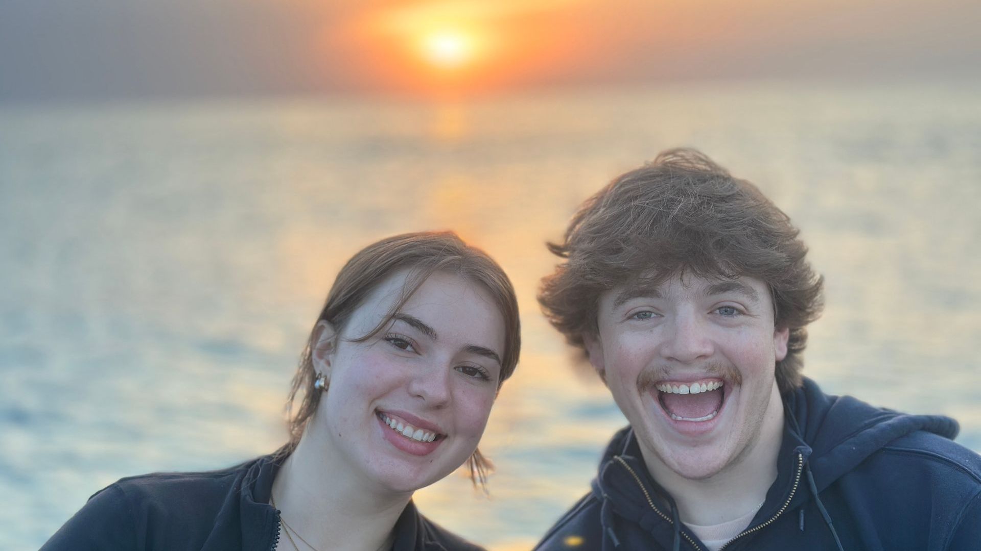 Couple smiling with the rising sun in the background
