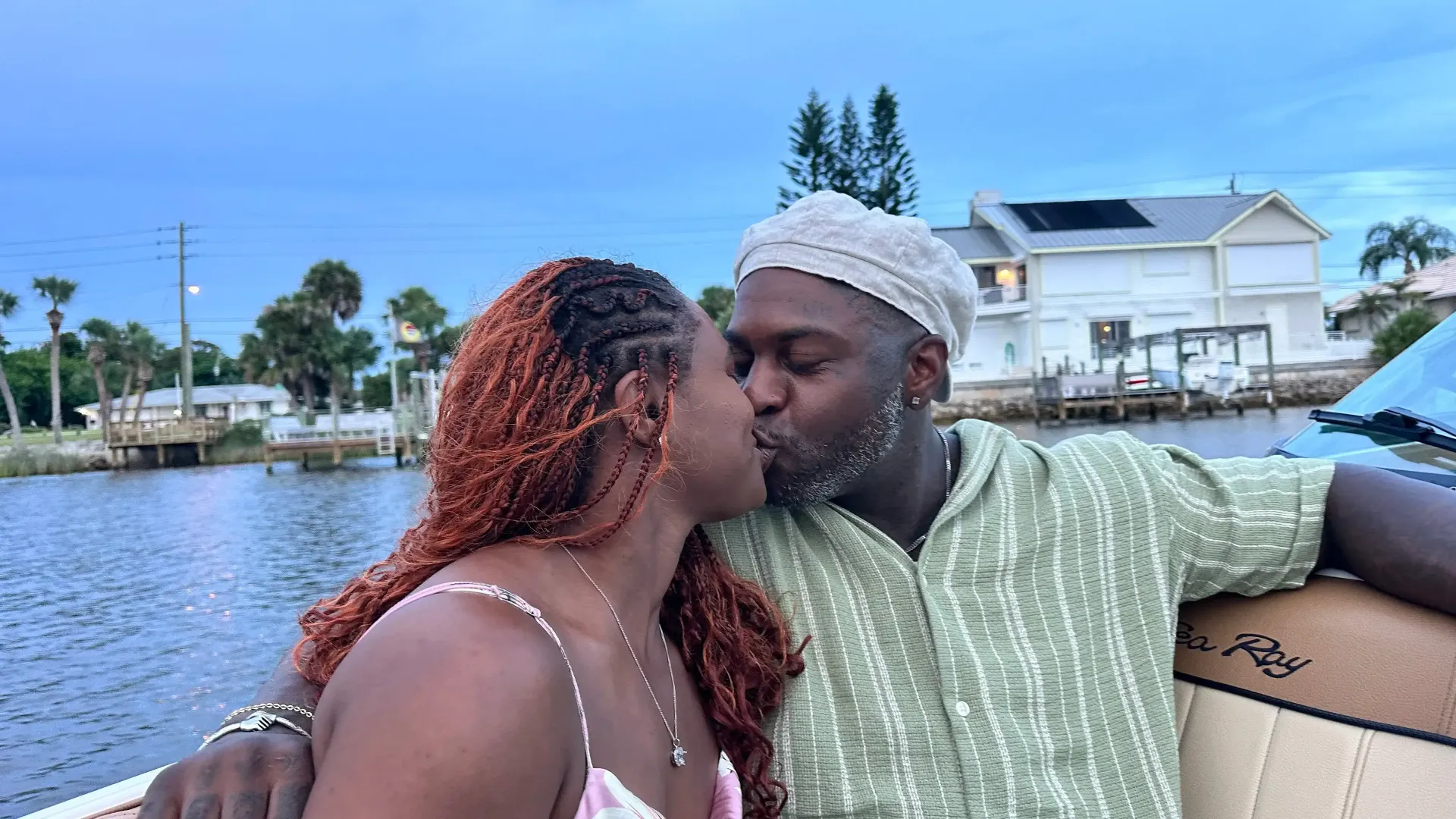 A couple kissing on a boat, enjoying a serene evening on the water.