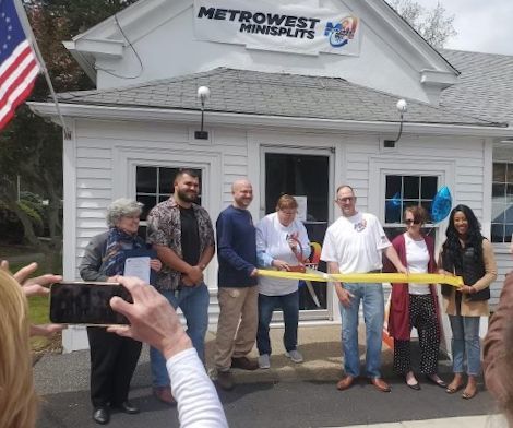 A group of people standing in front of a building that says metrowest minisplits