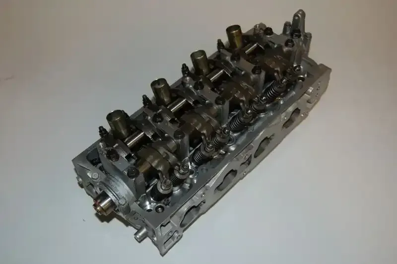 A close up of a cylinder head on a white surface