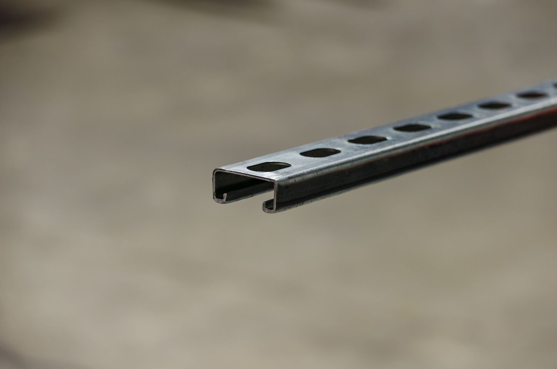 Close-up of a metal strut channel with pre-punched holes, safety standards of UL listed hardware 