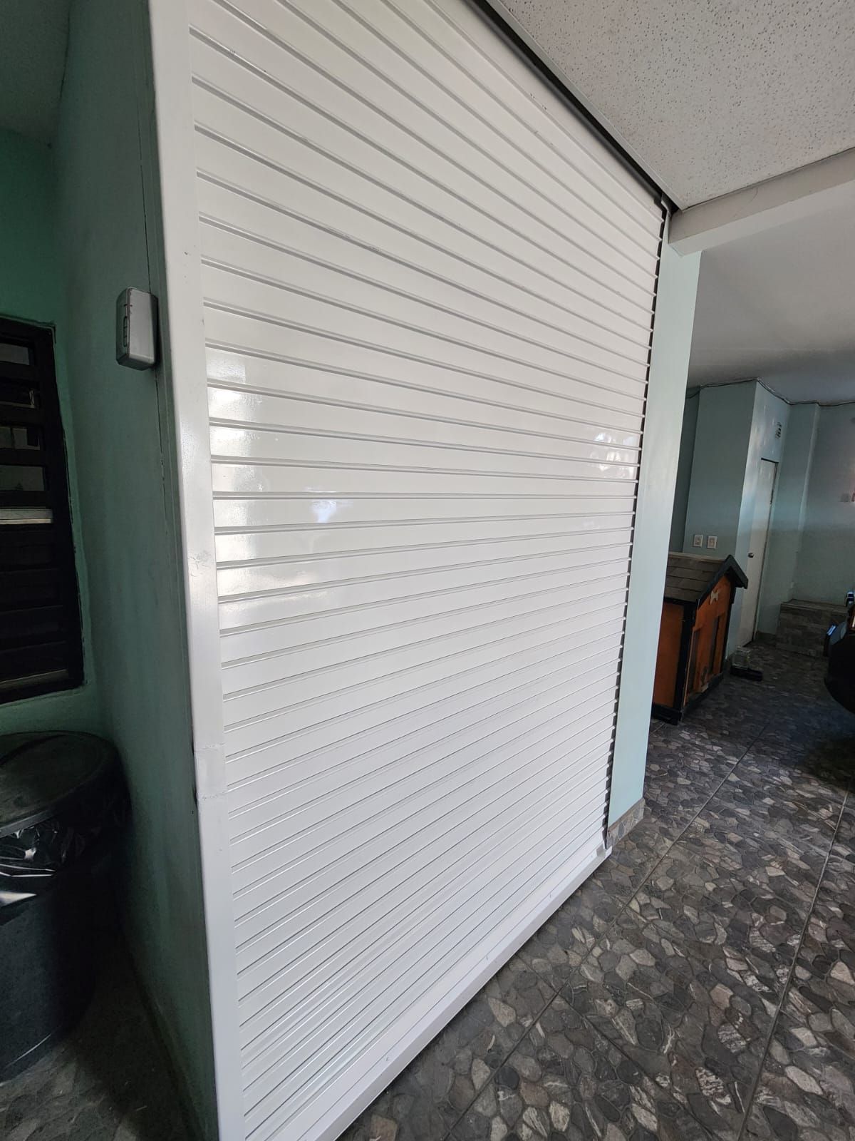 Una puerta de garaje blanca se encuentra en una habitación junto a una ventana.