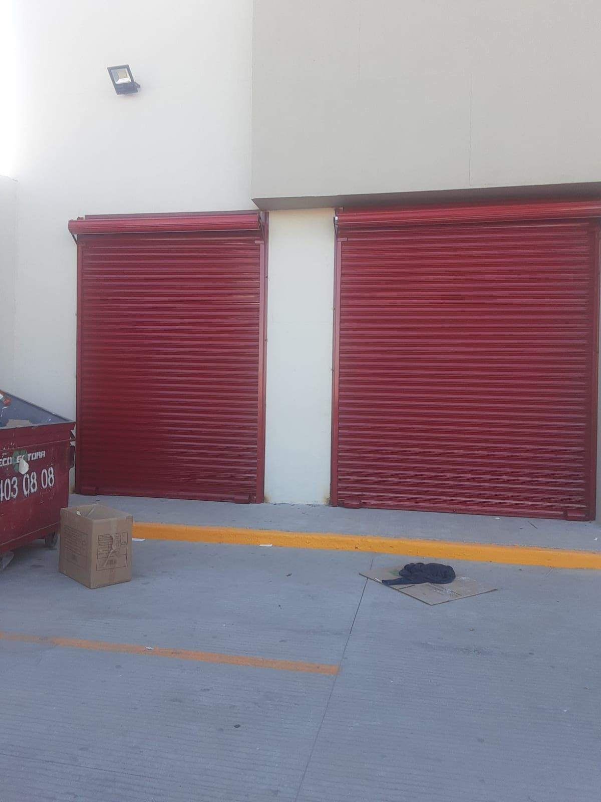 Una puerta de garaje roja con una caja delante.