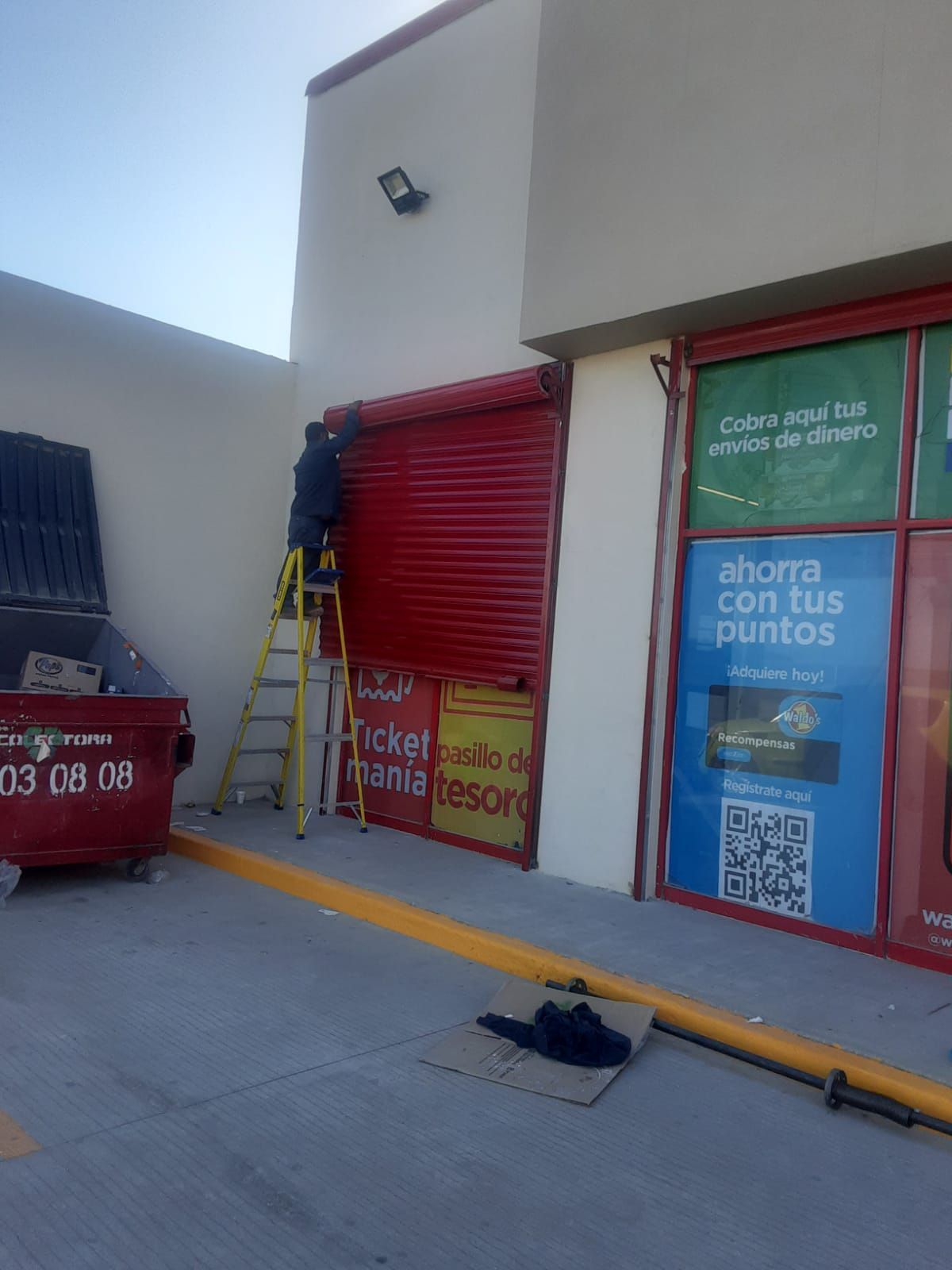 Un hombre está parado en una escalera frente a una tienda.