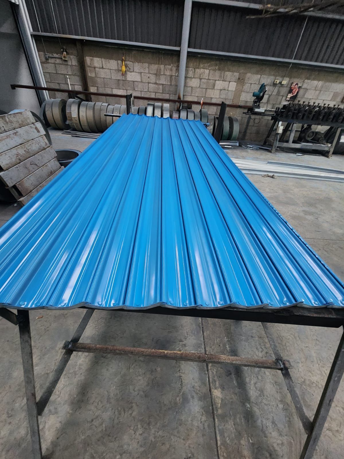 Un techo de metal azul está colocado encima de una mesa de metal.