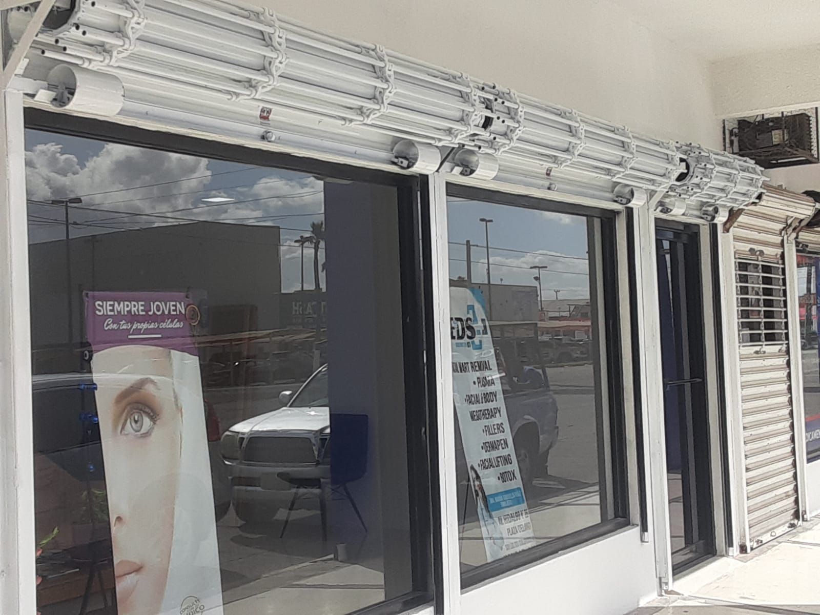 El frente de una tienda con una foto del rostro de una mujer en el escaparate.
