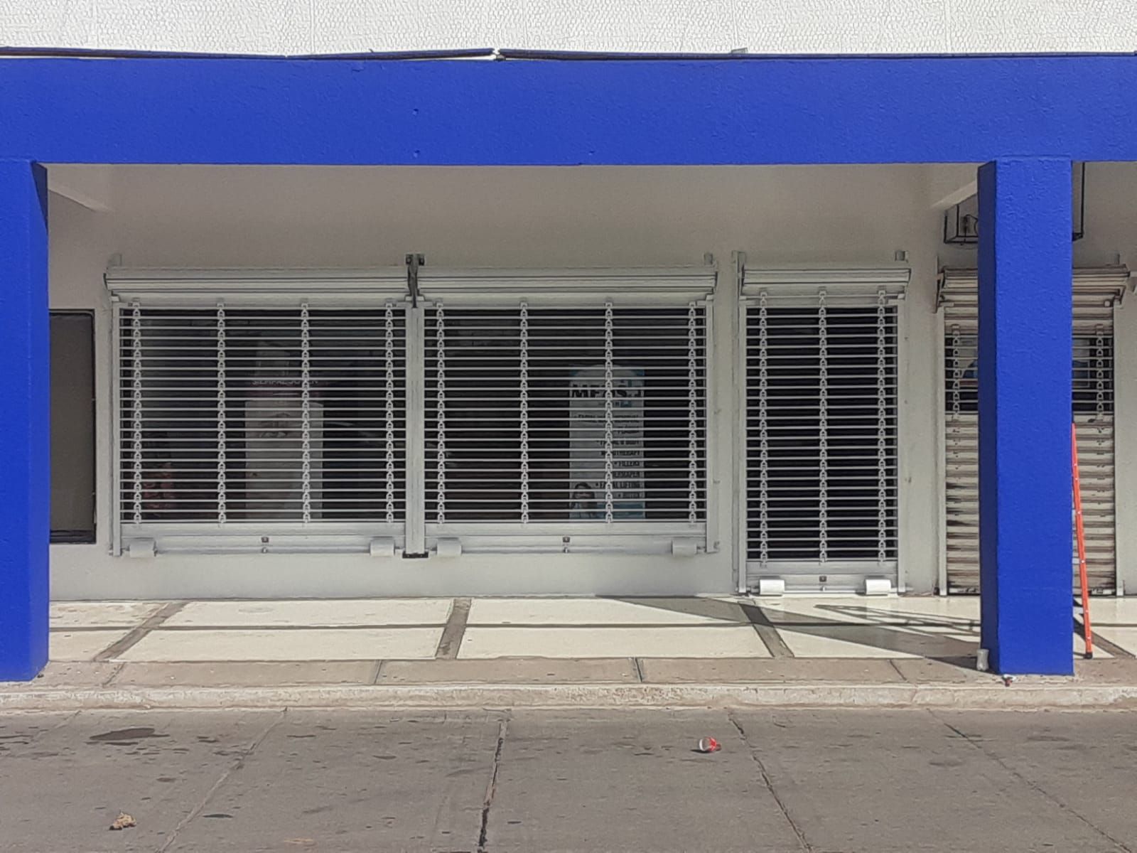 Un edificio con un pilar azul y un toldo azul.