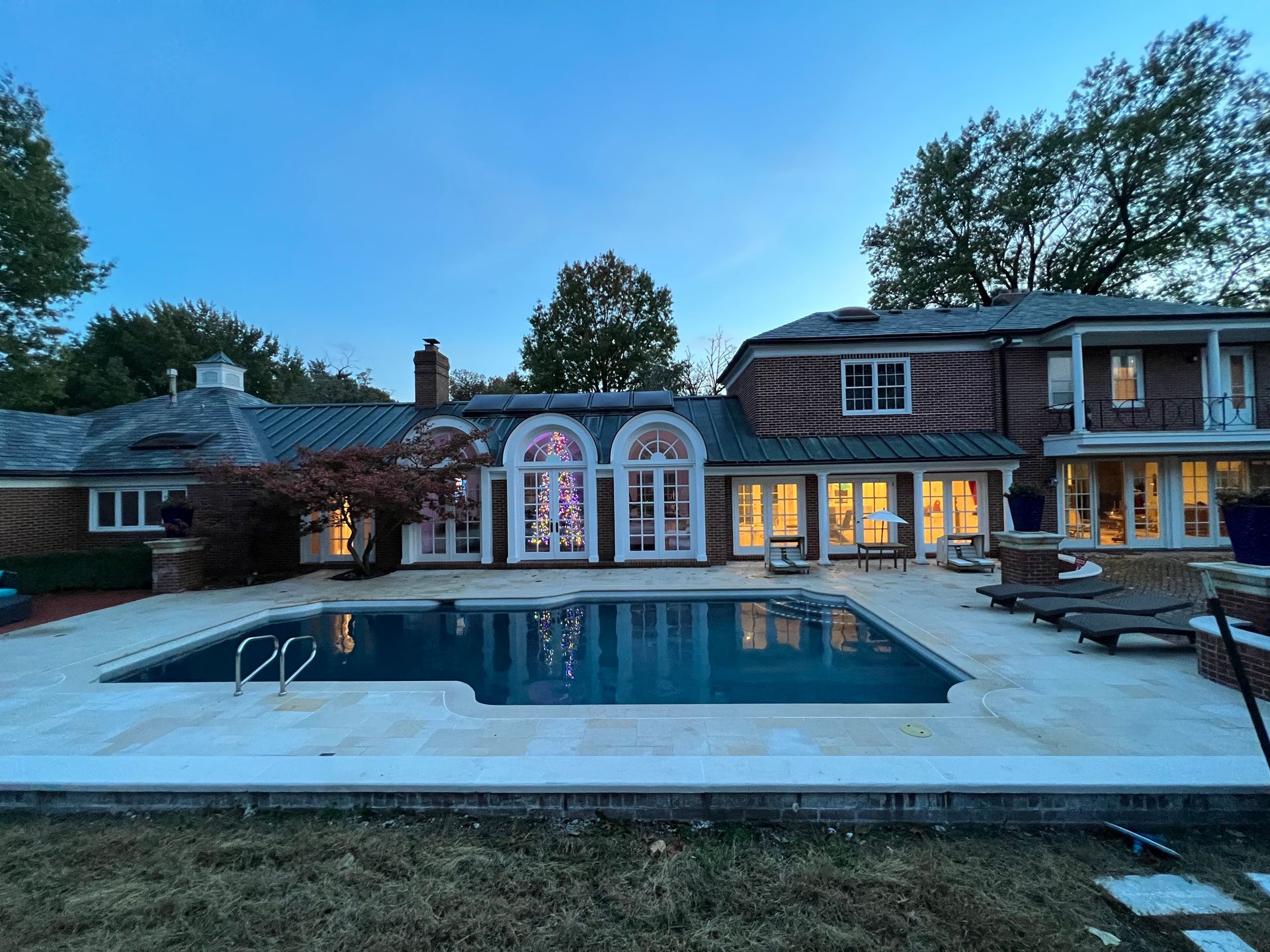 A large house with a large swimming pool in front of it.