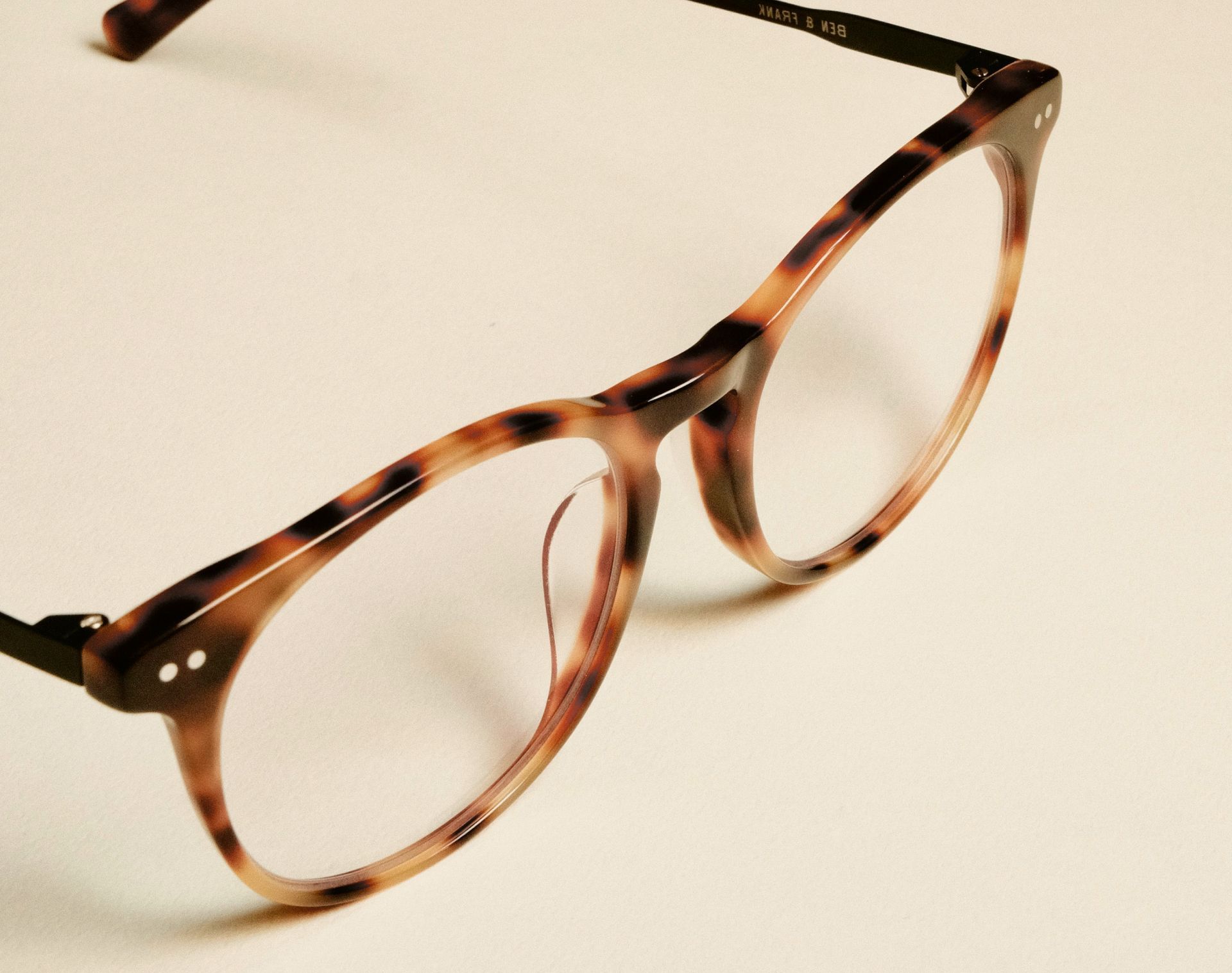 Tortoiseshell eyeglasses on a light surface.