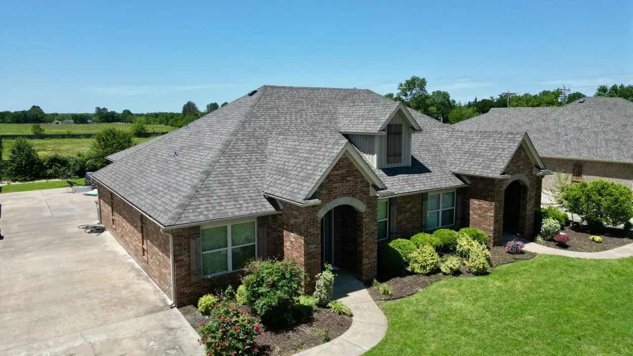 Architectural asphalt shingles installation on a brown brick residential home in Maryland.