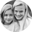 Two young girls with long blonde hair smiling, close up in a circle.