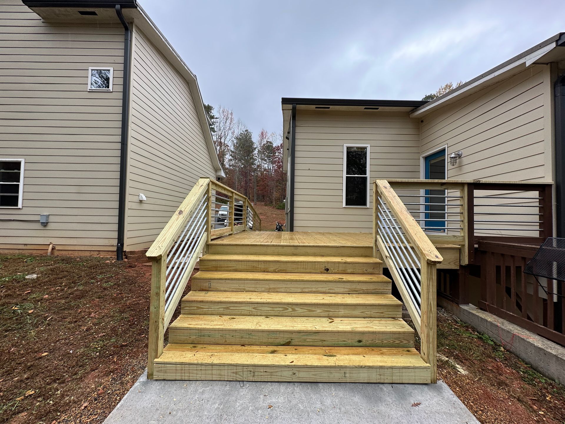 A wooden deck with stairs leading up to a house.