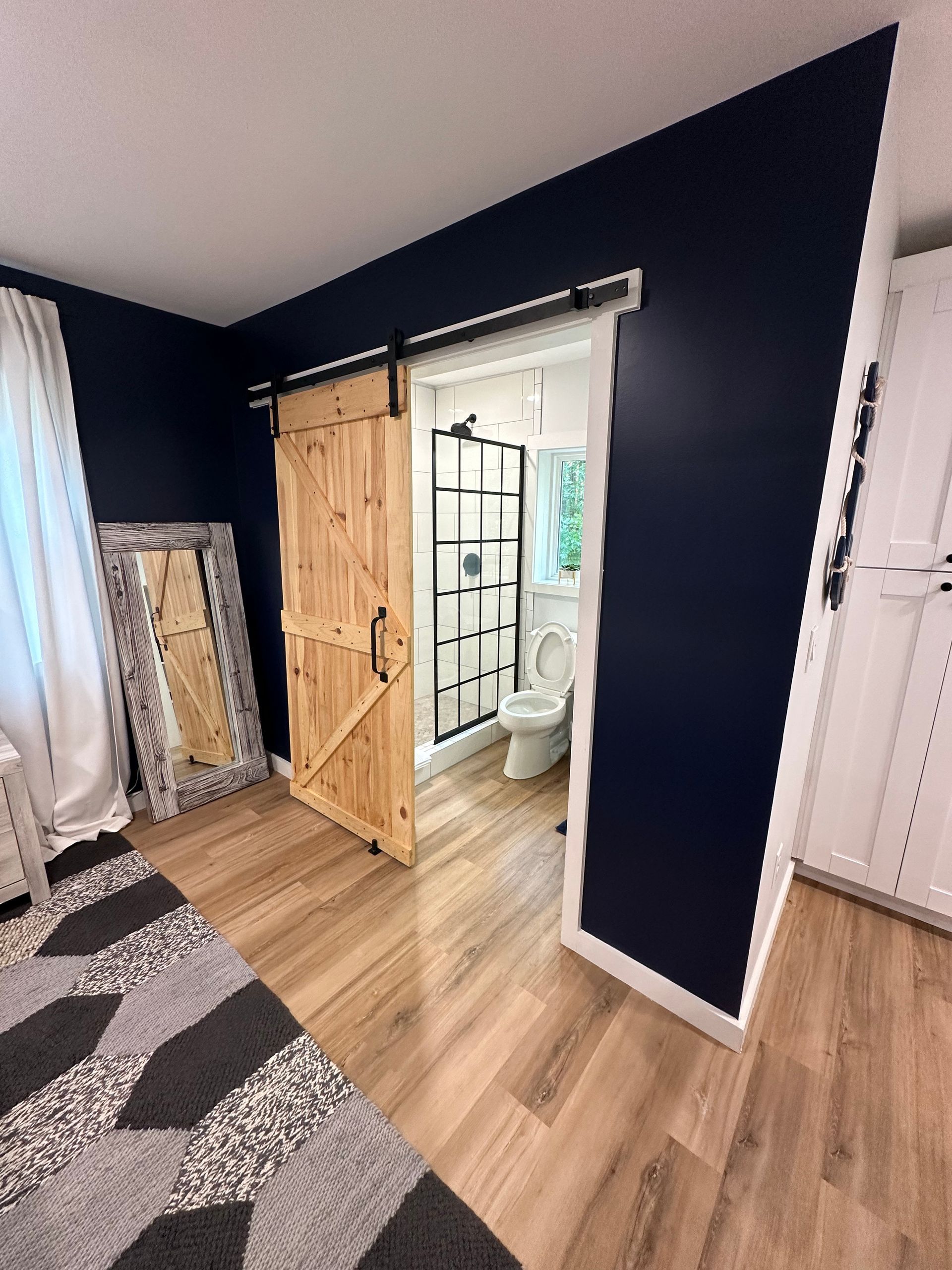 A bathroom with a sliding barn door and a toilet