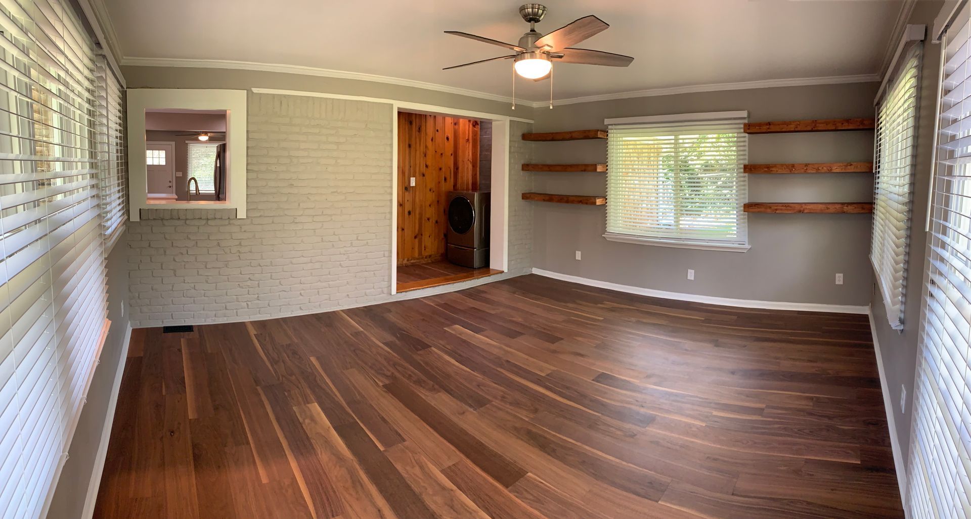 A living room with hardwood floors and a ceiling fan.