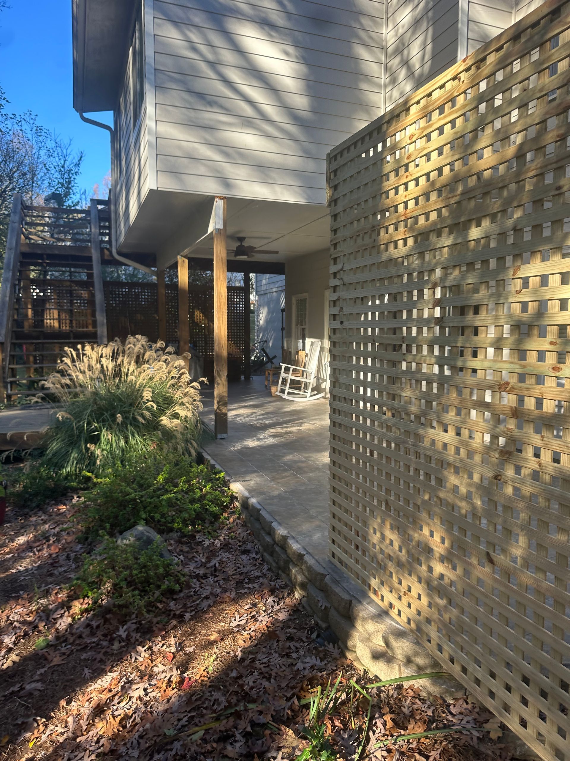 A house with a wooden fence and a rocking chair on the porch.