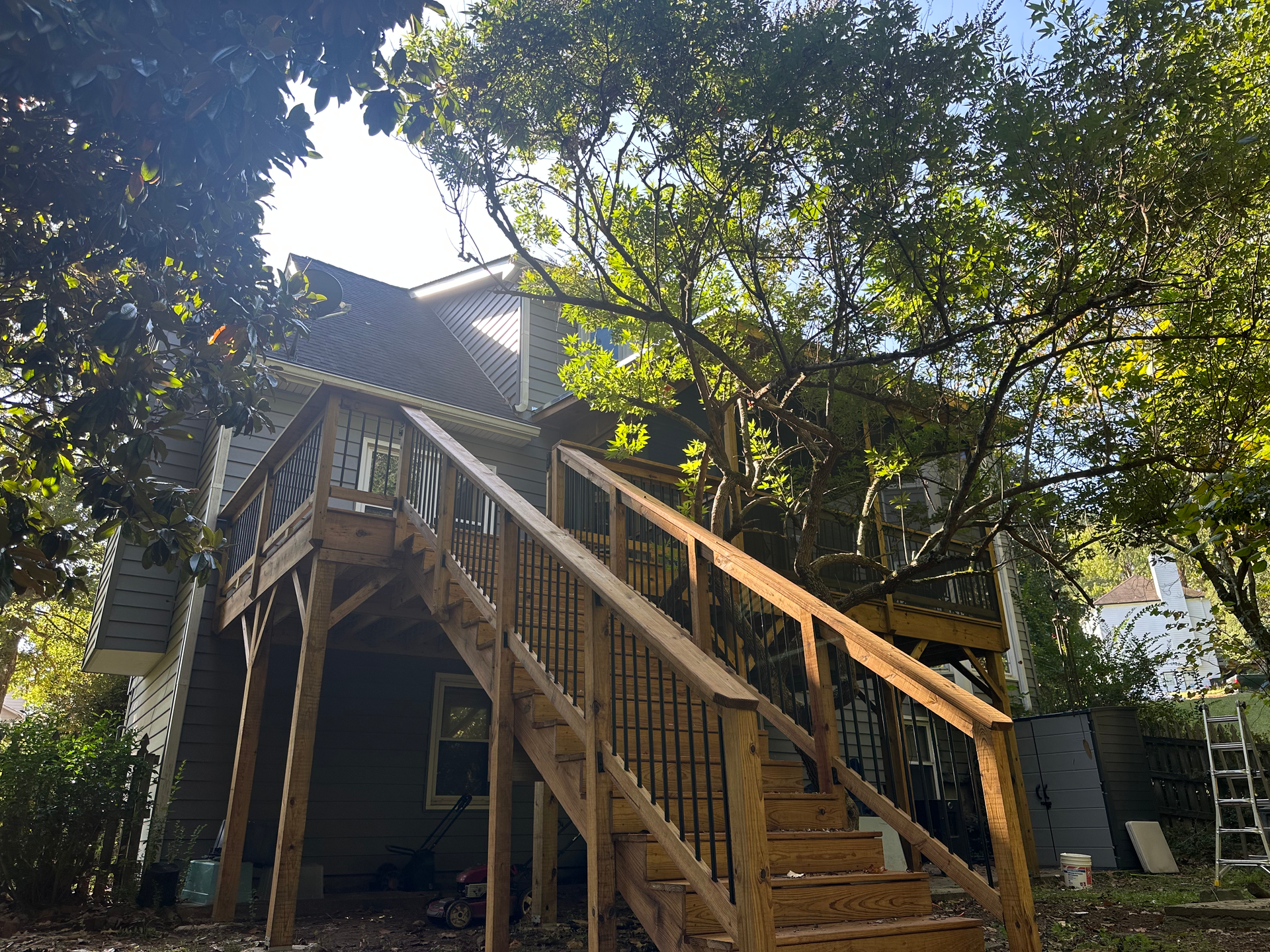 A house with a wooden deck and stairs leading up to it.