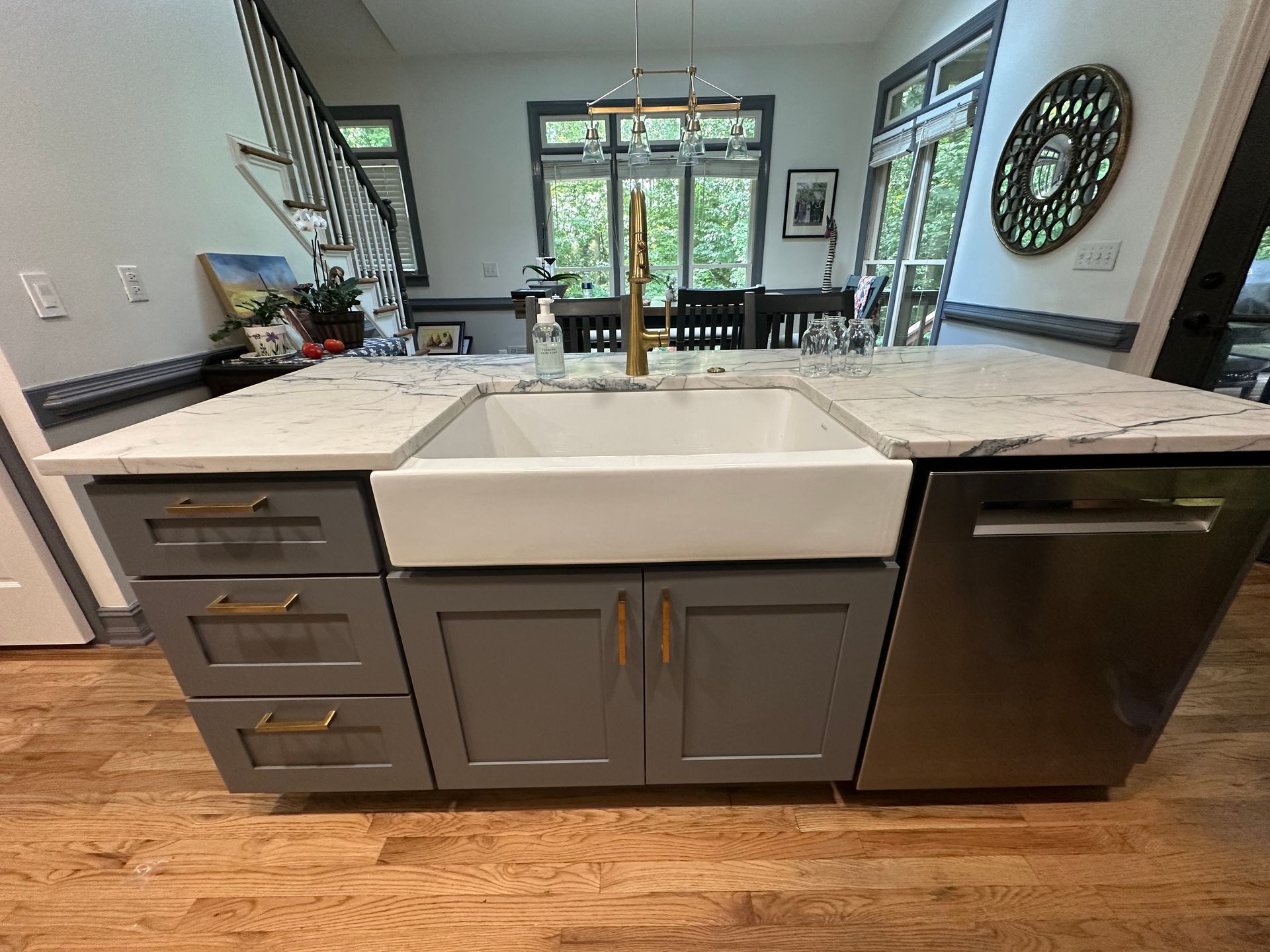 A kitchen with a sink , cabinets , and a dishwasher.