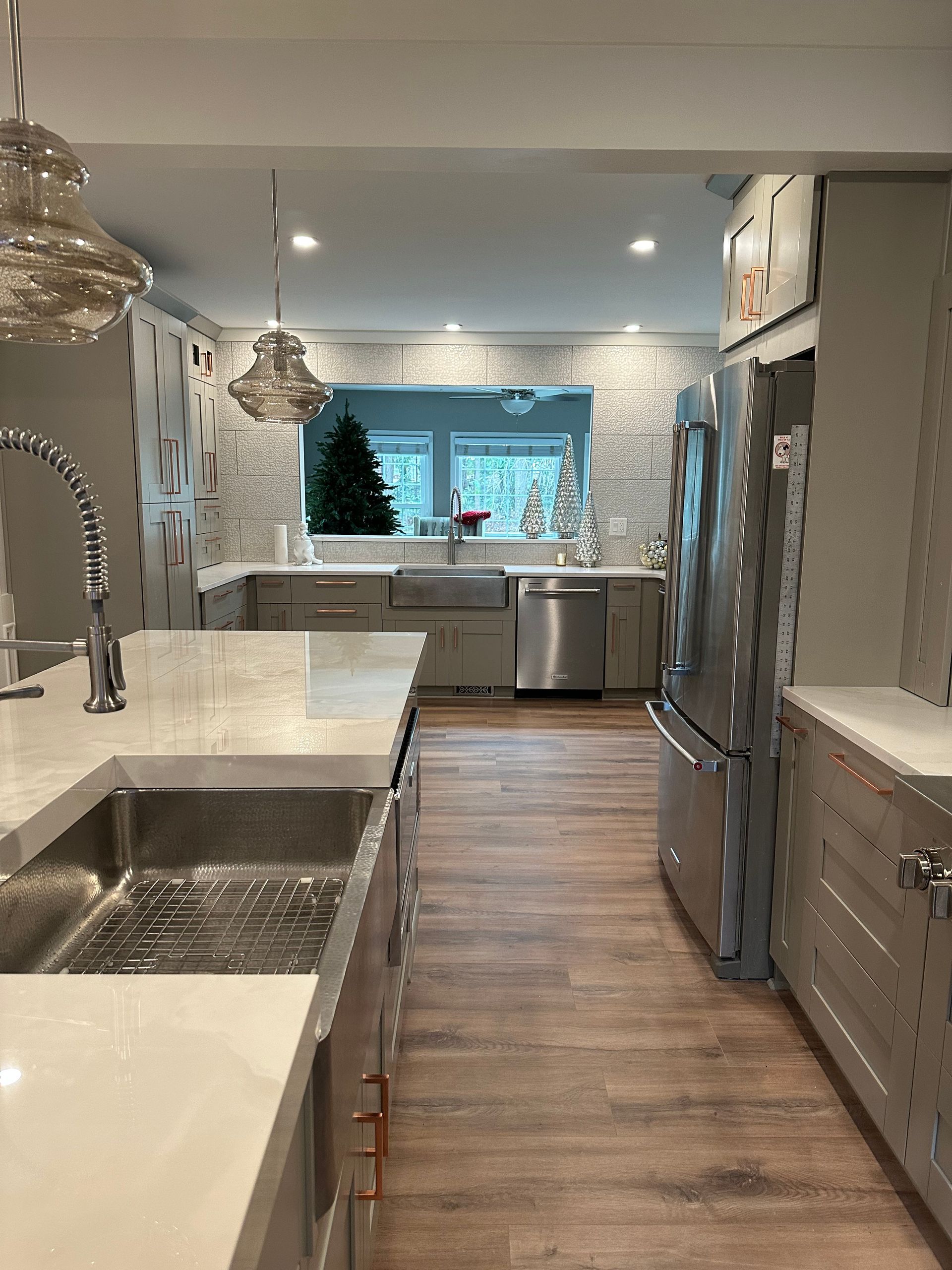 A kitchen with stainless steel appliances , a sink , and a refrigerator.