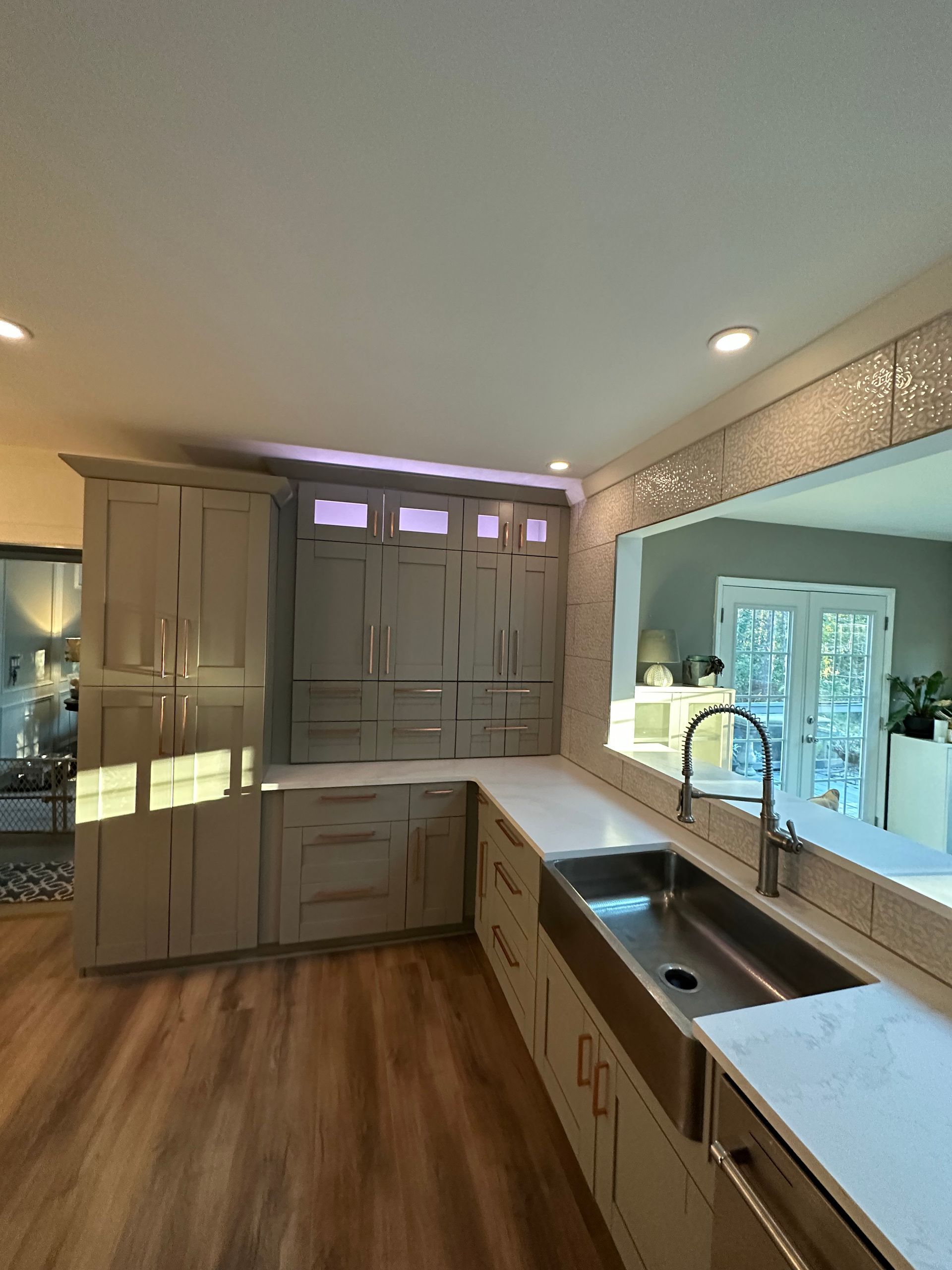 A kitchen with a sink and a large mirror