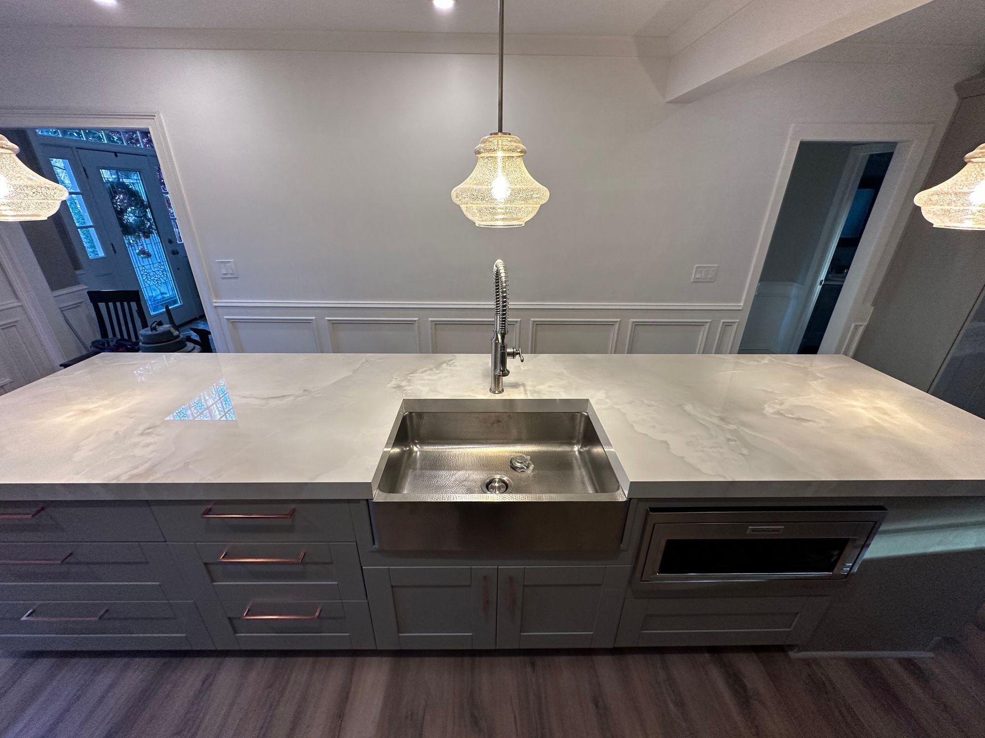 A kitchen with a large island and a stainless steel sink.
