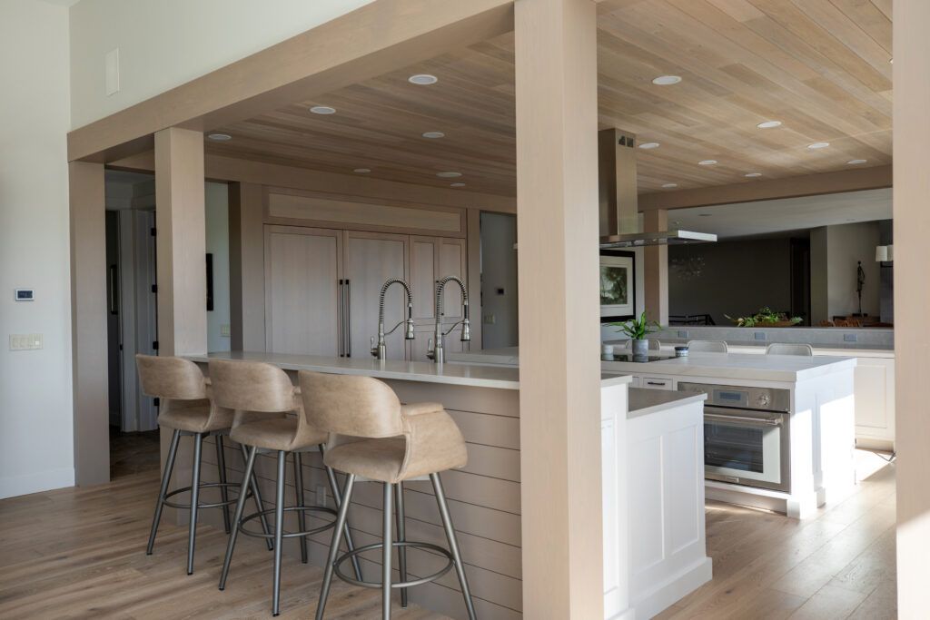 A kitchen with a large island and stools in it