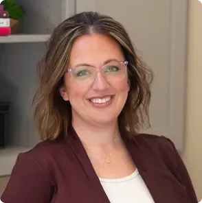 A woman in a blue and white shirt is smiling for the camera.