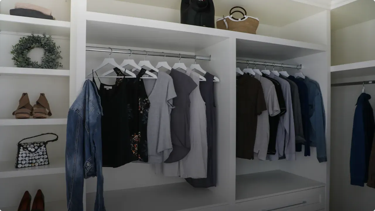 A walk in closet filled with clothes and shoes.