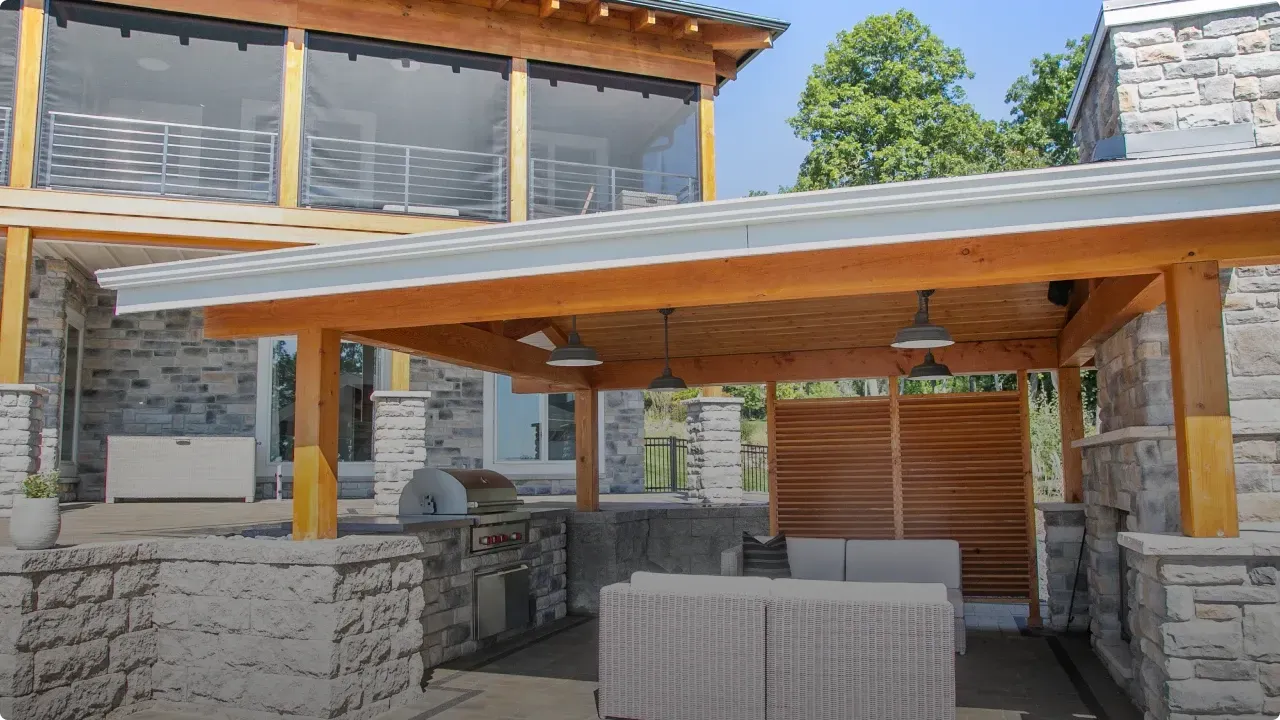 A patio with a wooden roof and a couch underneath it.