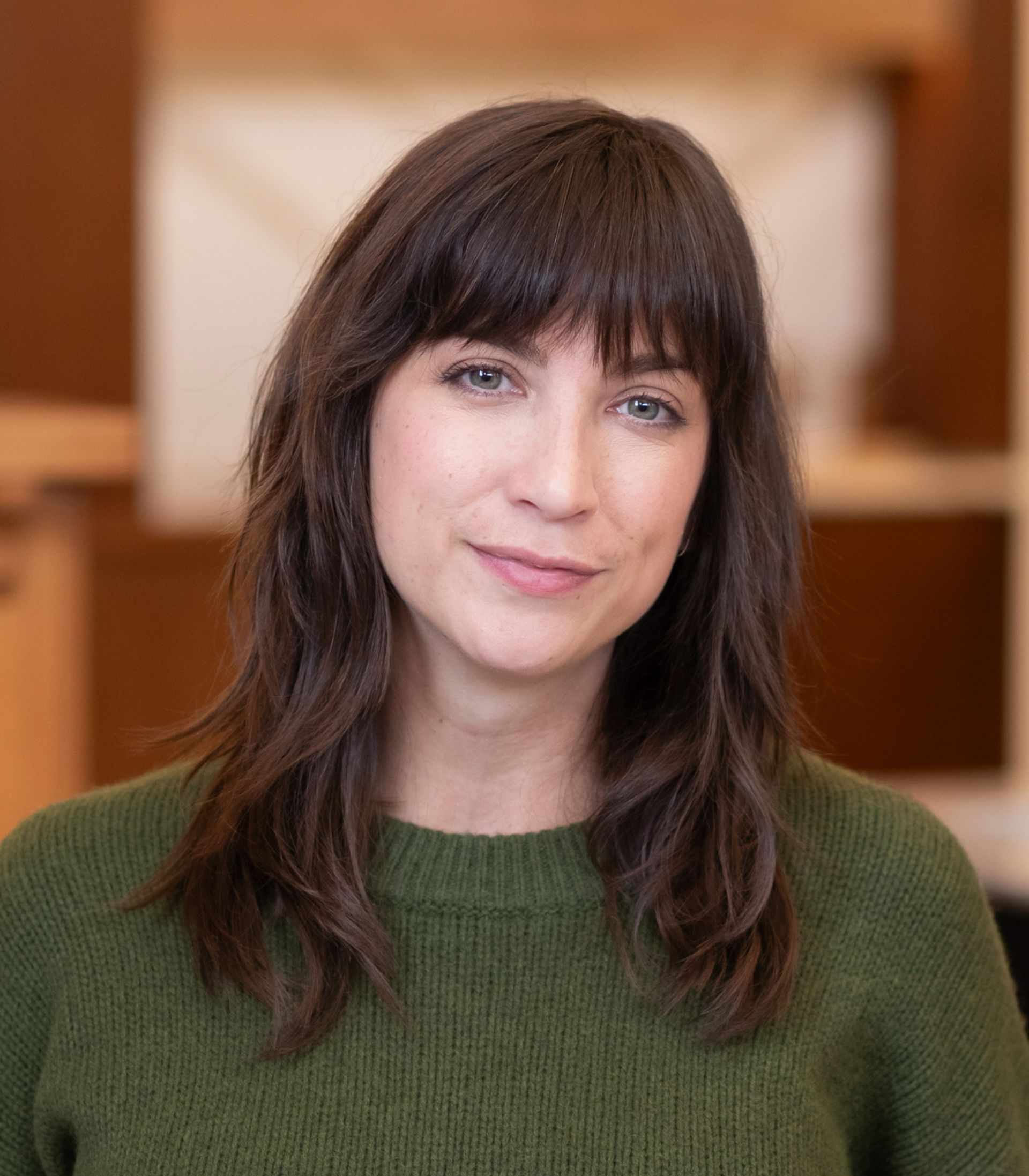 A woman in a blue and white shirt is smiling for the camera.