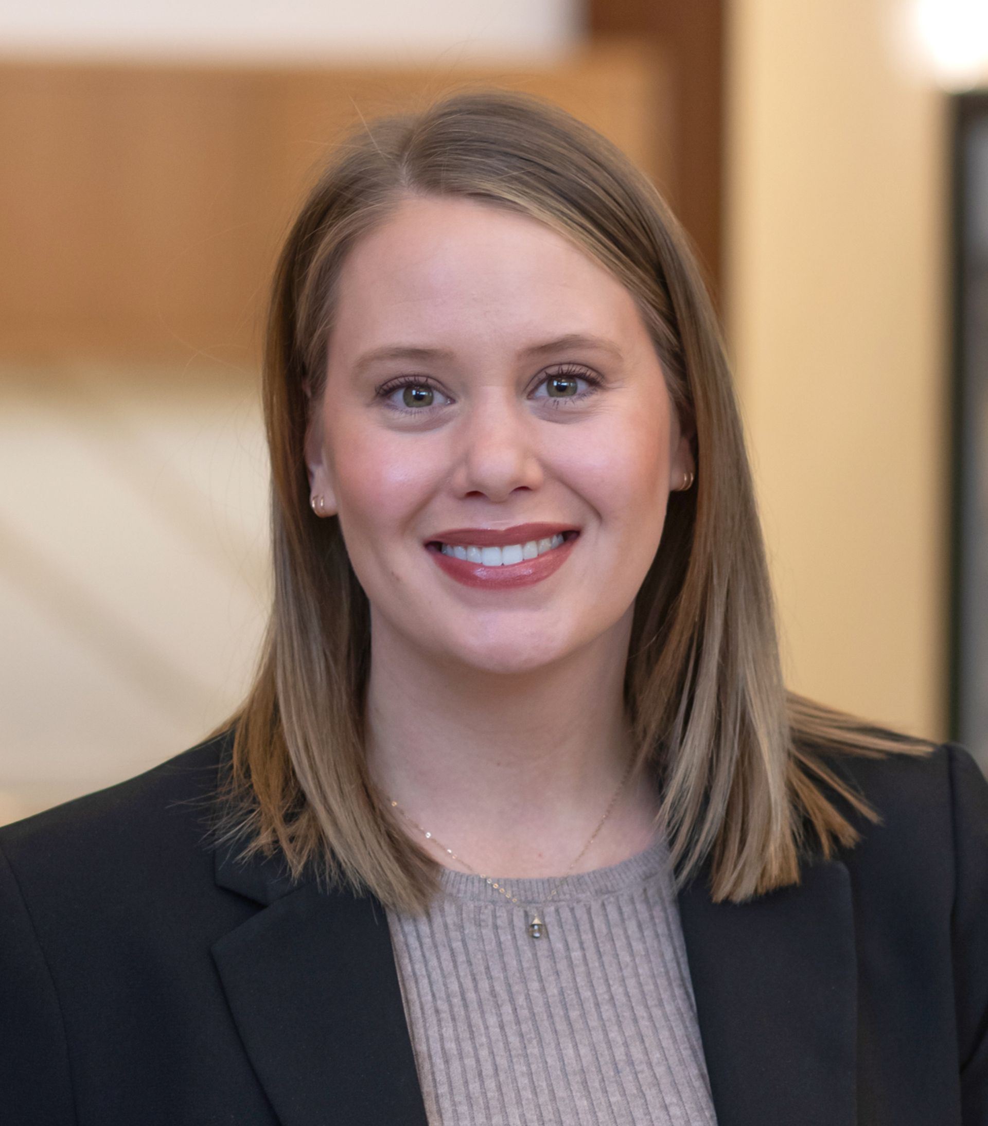 A woman in a blue and white shirt is smiling for the camera.