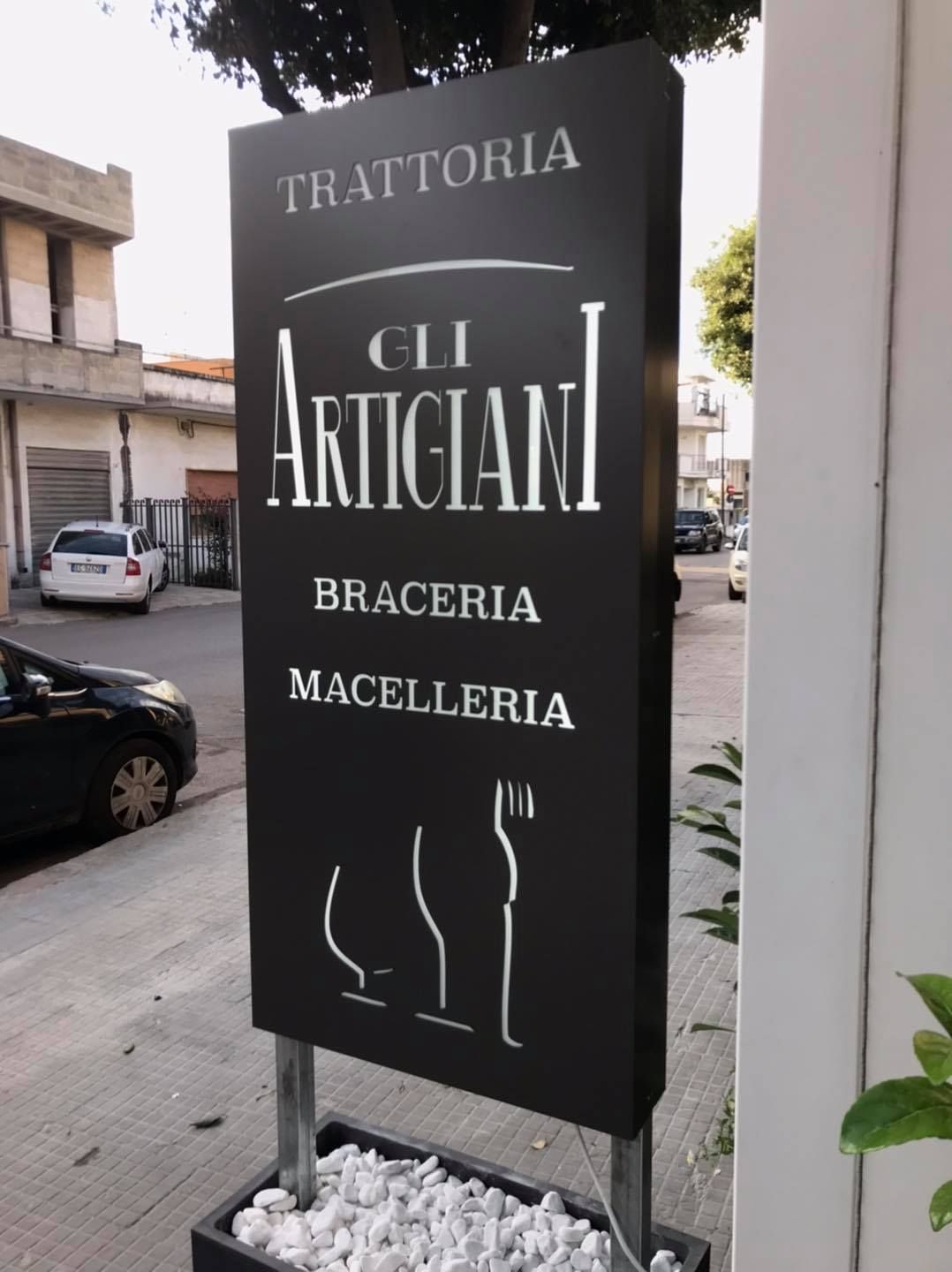 A sign that says trattoria gli artigiani on it