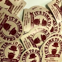 Una pila di biglietti da visita di un barbiere con sopra un cappello e dei baffi.