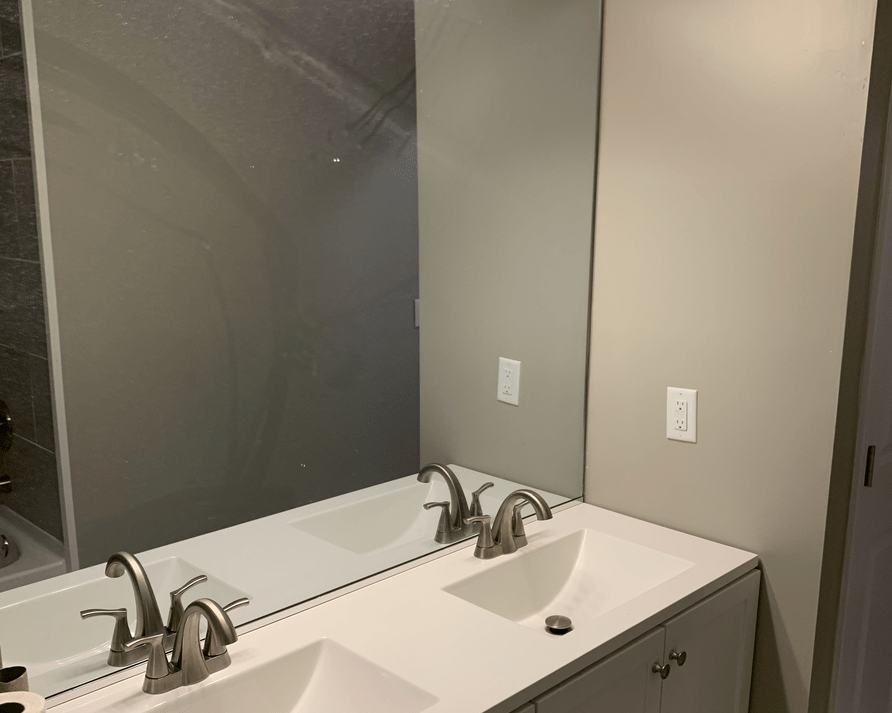 A bathroom with two sinks and a large mirror.