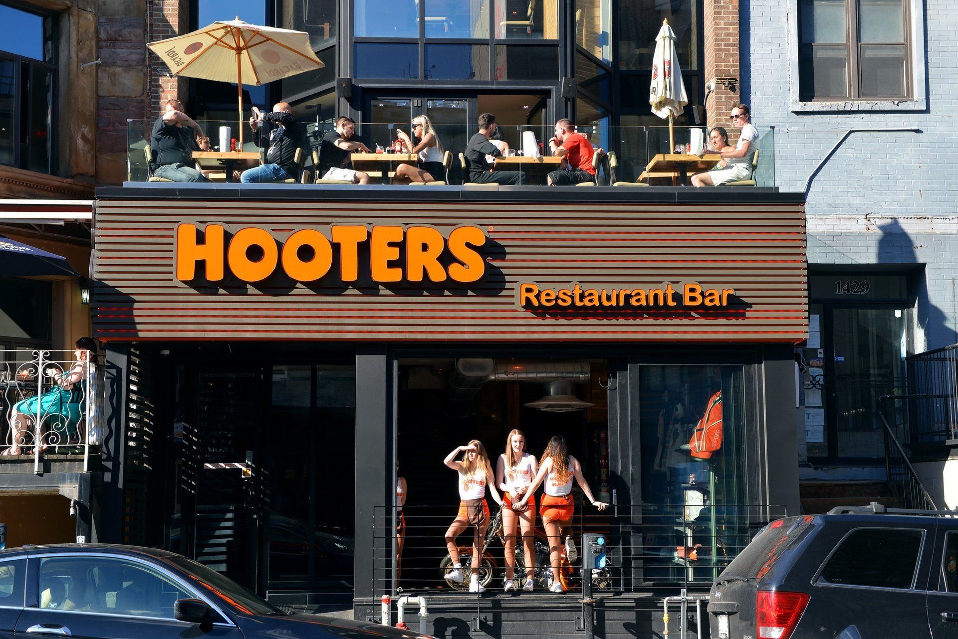 Hooters restaurant and bar with people sitting at tables outside