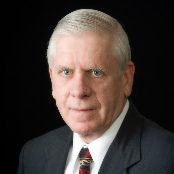 A man in a suit and tie against a black background