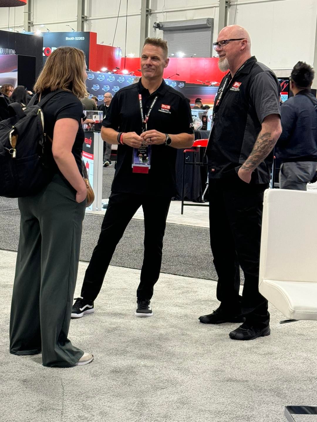 A group of people are standing in a room talking to each other.