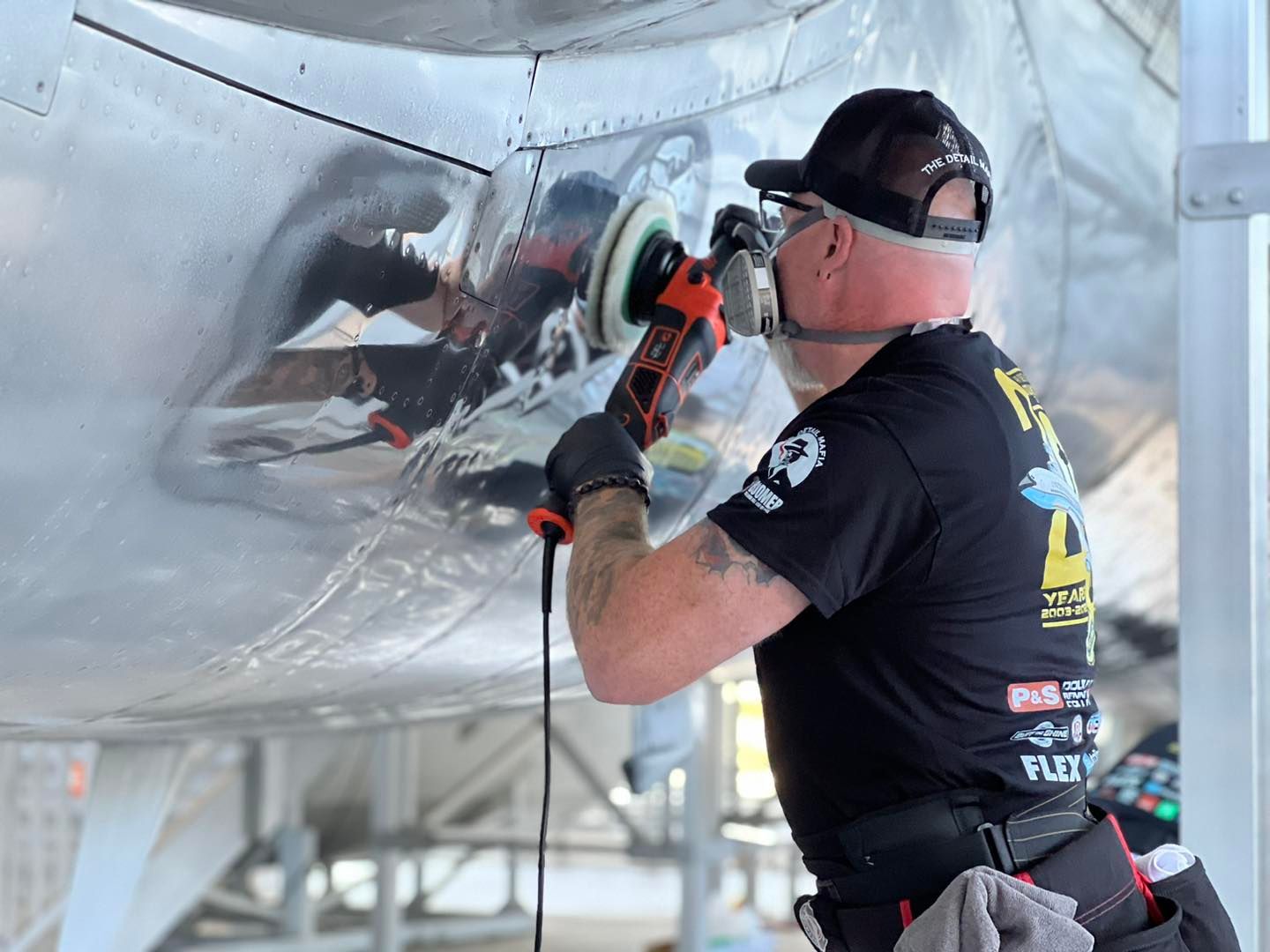 A man is polishing the side of an airplane.