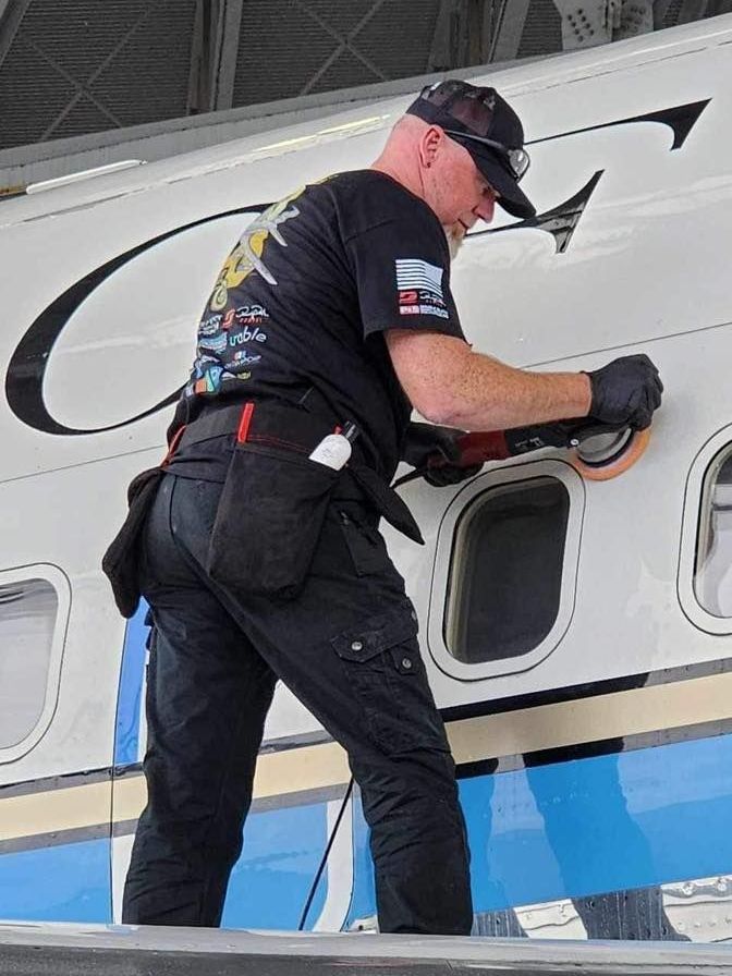 A man is working on a plane in a hangar.