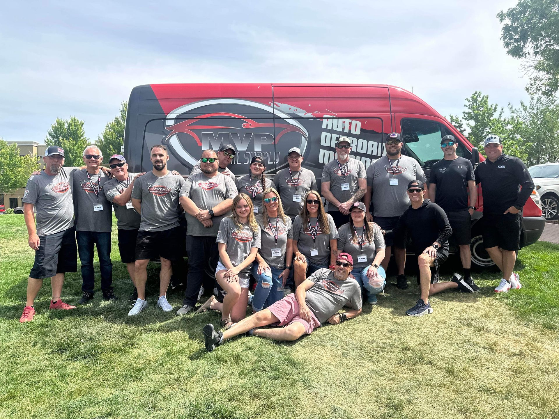 A group of people are posing for a picture in front of a van.