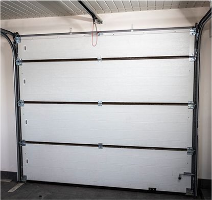 a white garage door is open in a garage