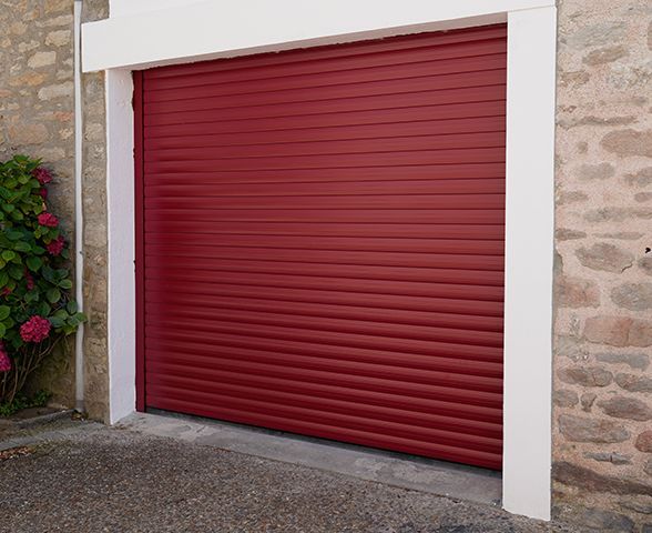 a red garage door is sitting on the side of a stone building .